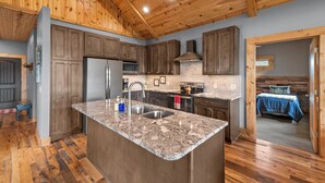 A kitchen with wooden cabinets, granite countertops, and a central island.