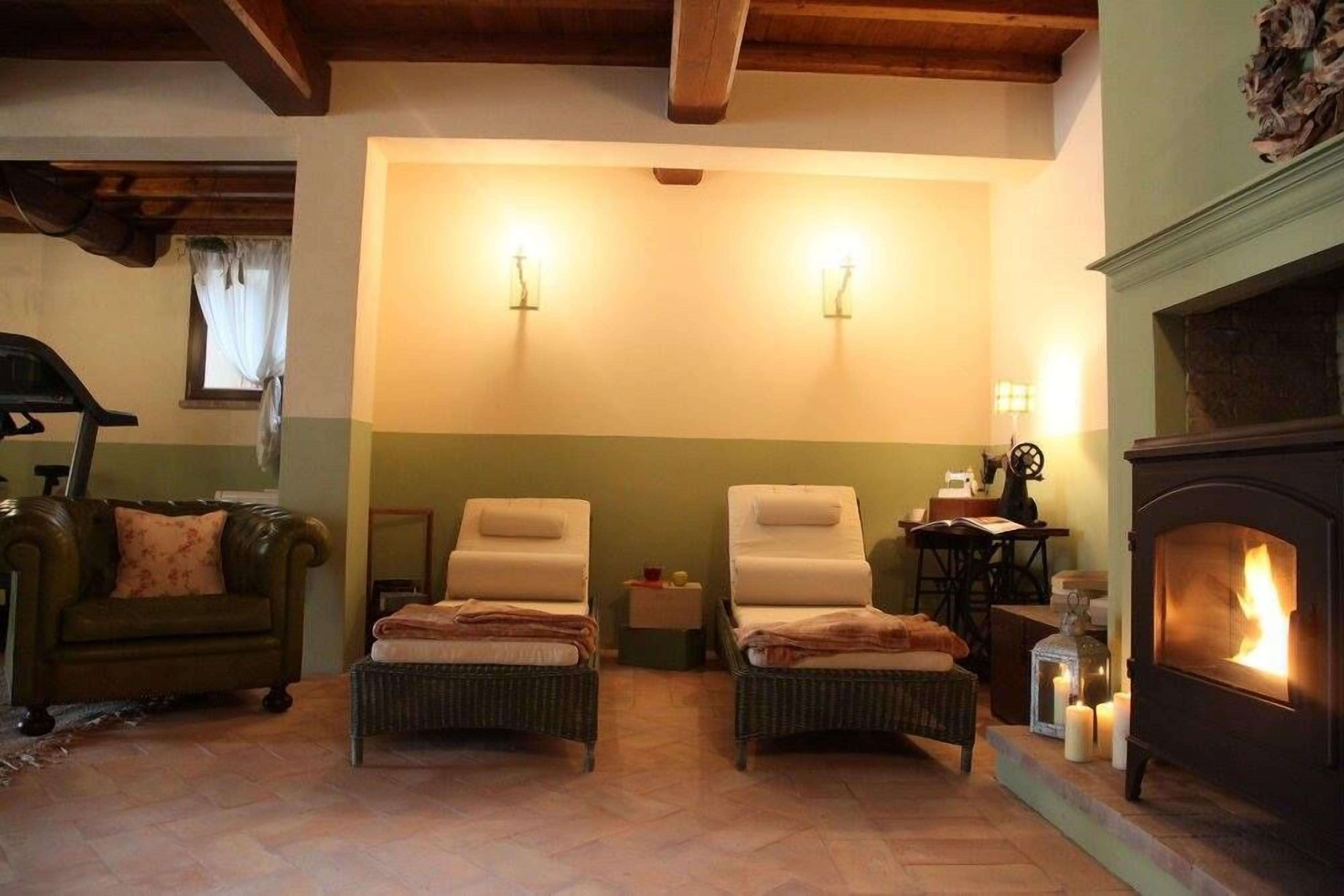 A cozy room with two lounge chairs, a fireplace, and a green wall.