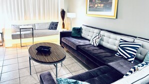 A modern living room with a grey sofa, a round coffee table, and a framed picture on the wall. - STRIP 2BR Condo NEARLVCC pet-Friendly Free-wifi on SALE Vegas music festival (Las Vegas)