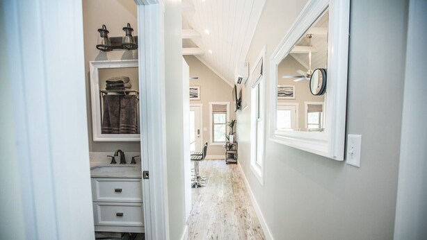 A hallway with a built-in closet, a mirror, and a ceiling fan. - Coop's Coop: A newly renovated studio cottage (Hendersonville)