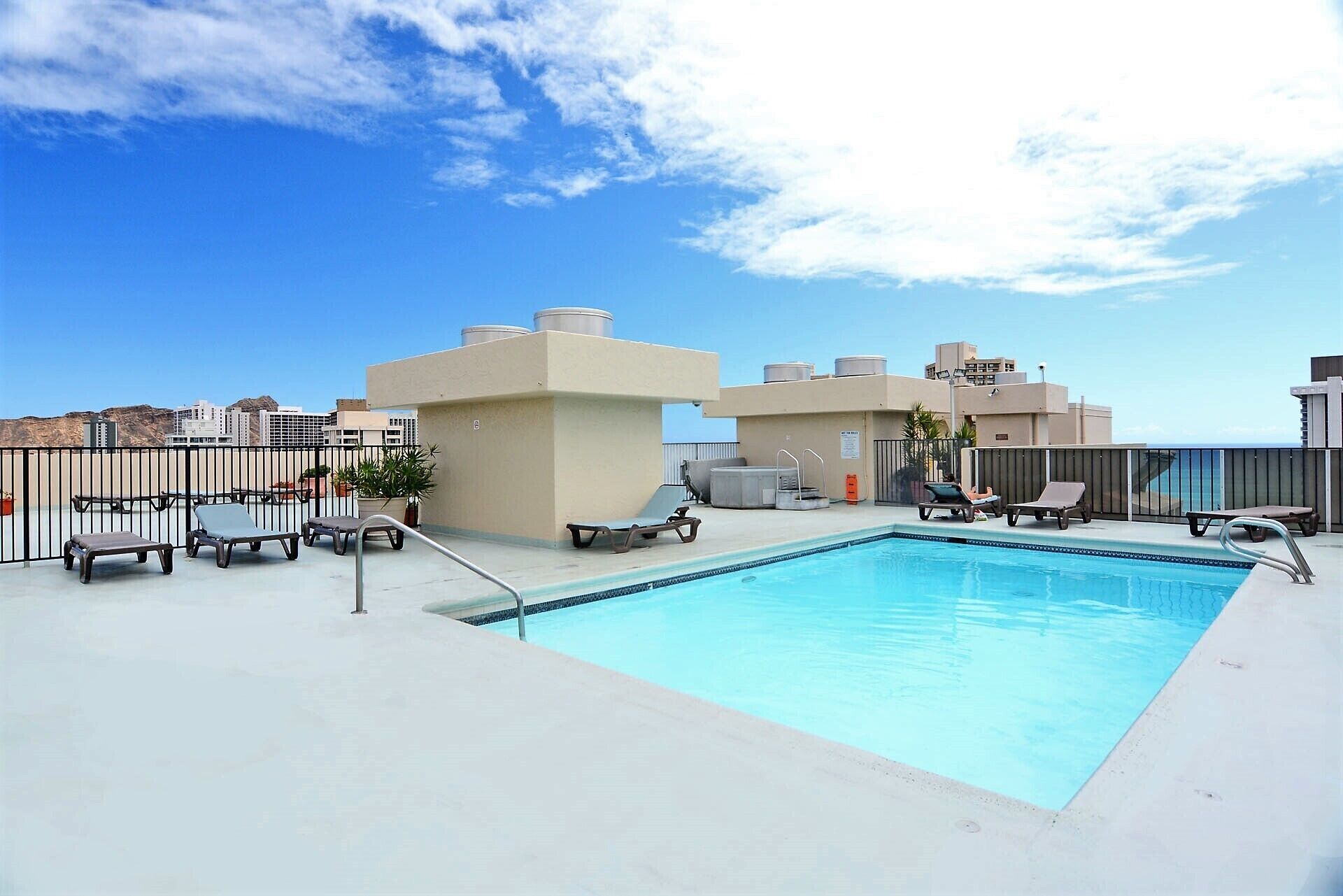 A rooftop pool area with lounge chairs and a swimming pool.