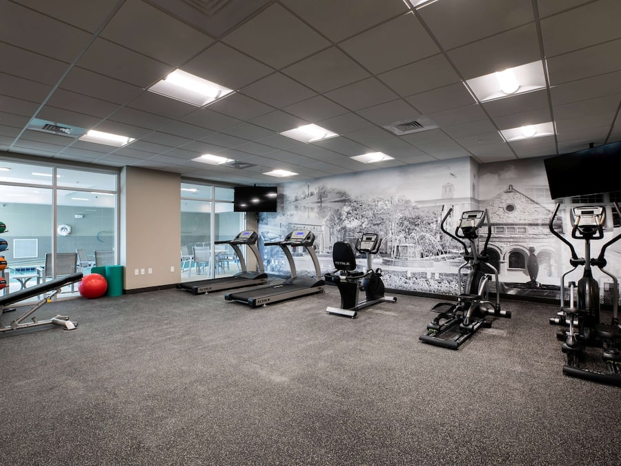 Et fitnesscenter med løbebånd, crosstrainere og vægte.