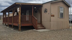A small, single-story building with a porch and a staircase leading to the entrance. - Ranch House (Thompson Springs)