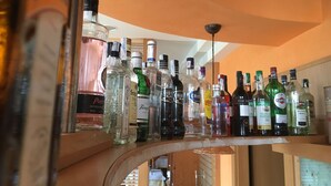 A bar area with a curved counter displaying various liquor bottles.