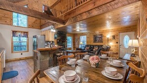 A wooden cabin interior with a dining table set for four, a kitchen area, and a cozy living space. - PRIVATE LOG CABIN l PET FRIENDLY | HOT TUB l SAUNA (Cleveland)