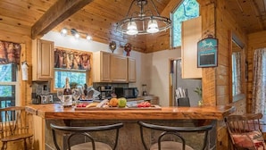 A wooden interior with a bar area, kitchen, and dining chairs. - PRIVATE LOG CABIN l PET FRIENDLY | HOT TUB l SAUNA (Cleveland)