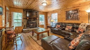 A log cabin interior with a stone fireplace, leather sofa, wooden flooring, and a stone wall. - PRIVATE LOG CABIN l PET FRIENDLY | HOT TUB l SAUNA (Cleveland)