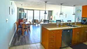 Una cocina amplia con armarios de madera, lavavajillas y una isla grande con un fregadero.