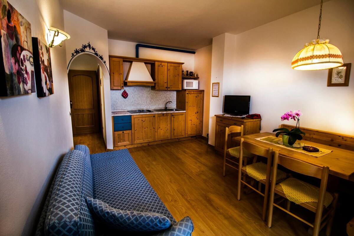A compact living space with a kitchenette, a dining area, and a sofa.