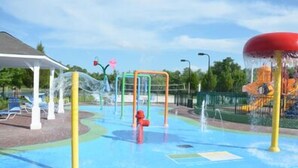 Un parque acuático con estructuras de juego y una zona de estar techada.