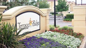 A sign for Terrace Ridge with a landscaped garden in front. - Magical Florida Getaway. (Davenport)