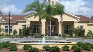 A building with a central fountain, a tower, and a symmetrical facade with arched windows. - Kumar's Kastle (Davenport)