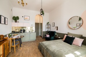Suite studio supérieure, 1 très grand lit, balcon | Aire de séjour | Téléviseur à écran plat