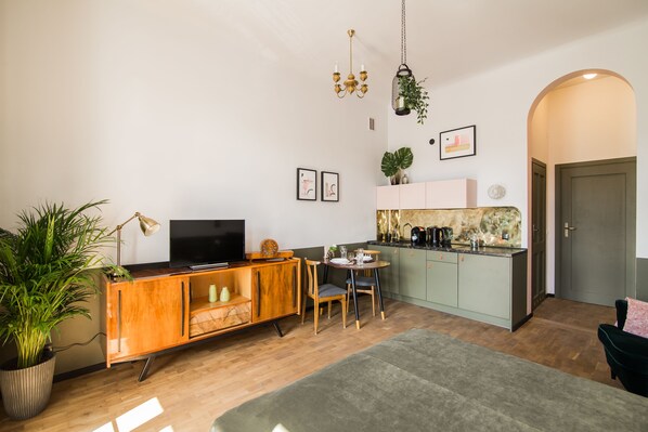 Suite studio supérieure, 1 très grand lit, balcon | Aire de séjour | Téléviseur à écran plat