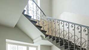 A staircase with ornate metal railings and a patterned floor. - Aparthotel Nowy Świat 28 (Warsaw)