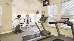A gym with treadmills, a weight machine, and a television on the wall. - Silver Palm Retreat (Kissimmee)