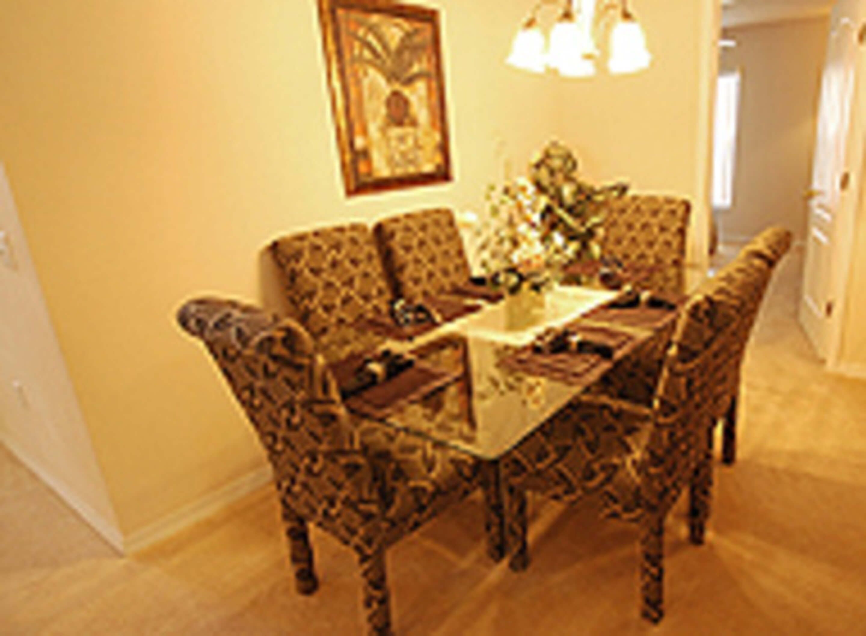 Un coin repas avec une table et des chaises à motifs.
