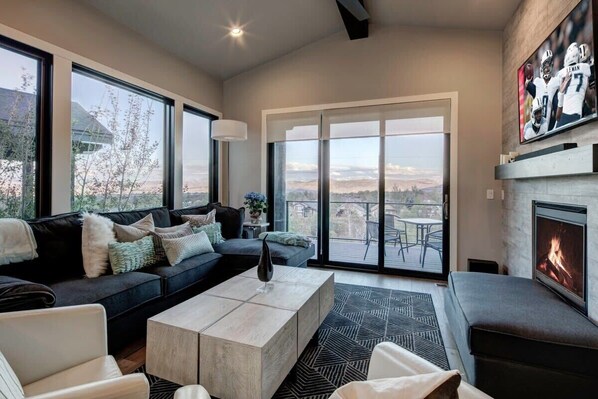 Una sala de estar moderna con un sofá grande, una mesa de centro y una chimenea.