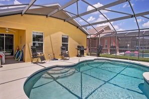 A covered swimming pool with lounge chairs and a barbecue grill. - Royal Ridge Retreat (Davenport)