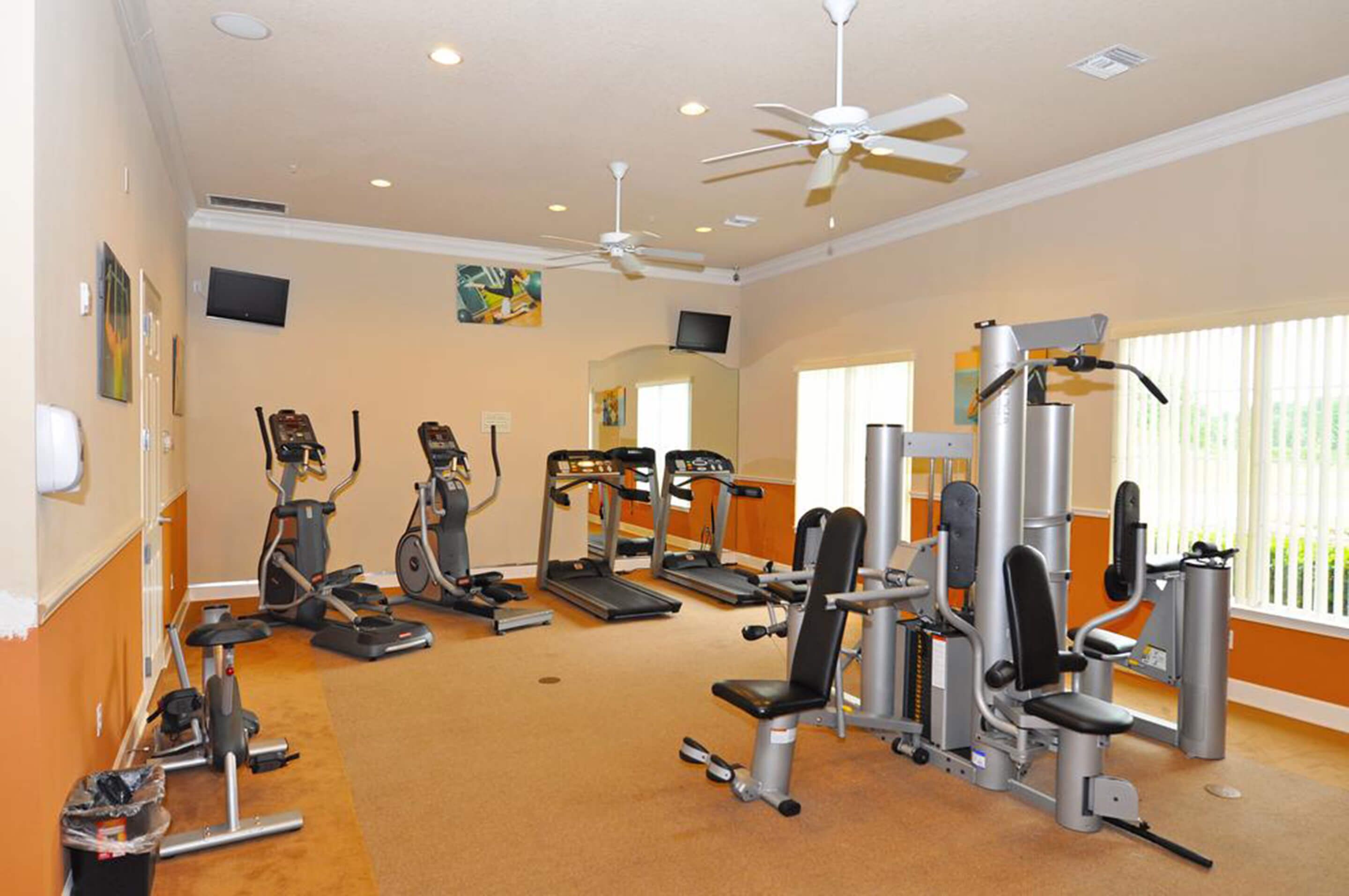 A gym with treadmills, elliptical machines, and weight equipment.
