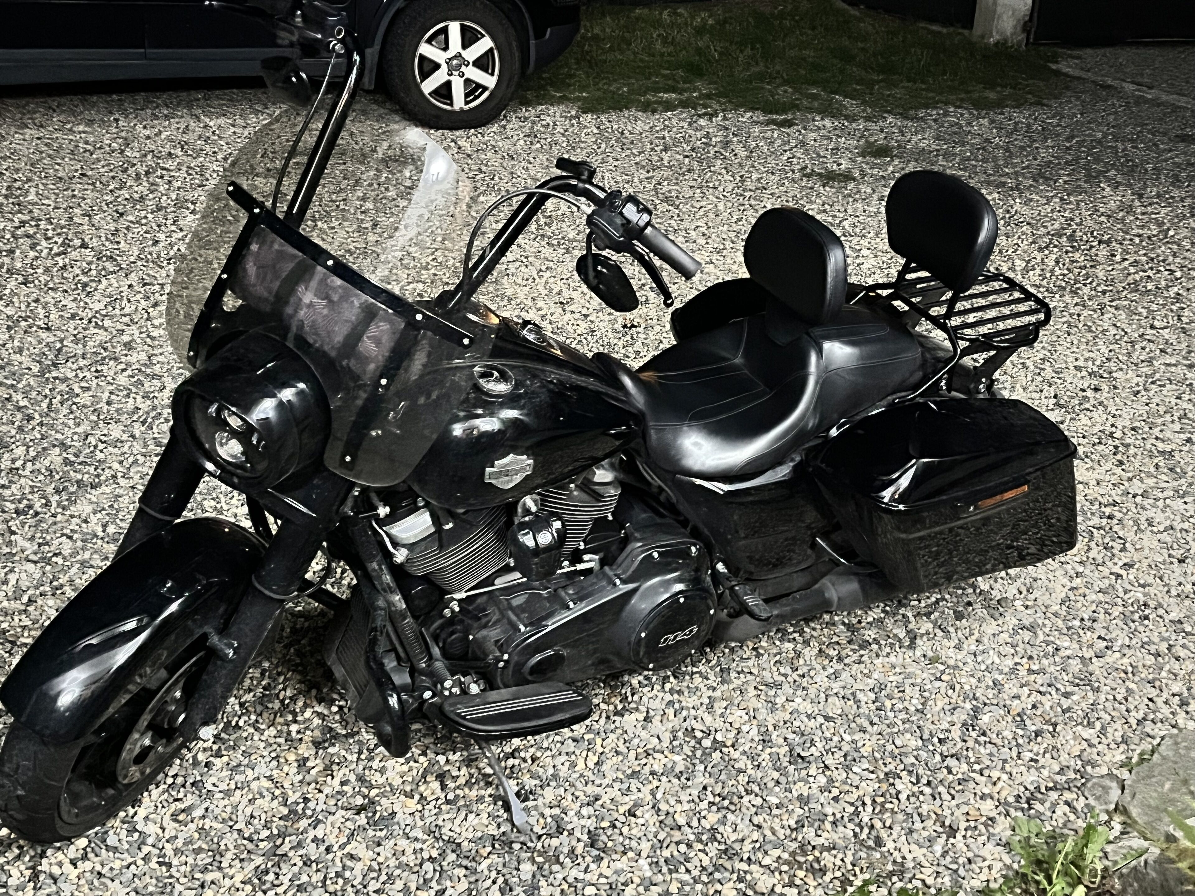 Una motocicletta parcheggiata su fondo ghiaioso.