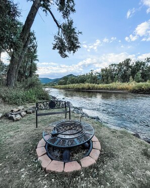 A riverside park with a metal fire pit and a bench. - Spacious riverside Lodge- Book now for ski season! Large pavilion and new deck (South Fork)