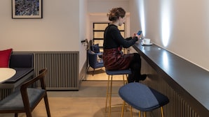 A modern interior with a bar area, seating, and a framed cityscape artwork. - The Resident Covent Garden (London)