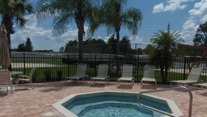 A swimming pool with a hot tub, surrounded by lounge chairs and a brick patio. - Royal Palm Villa (Kissimmee)