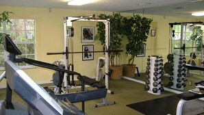 A gym with exercise equipment, a treadmill, and a mirror. - Royal Palm Villa (Kissimmee)
