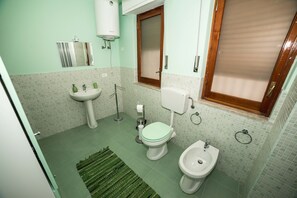 A bathroom with a toilet, bidet, sink, and a mirror. - Loft Notarbartolo 1 (Palermo)