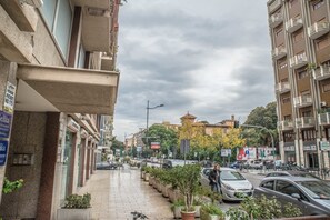 A city street with parked cars, a pedestrian walkway, and buildings with balconies. - Loft Notarbartolo 2 (Palermo)