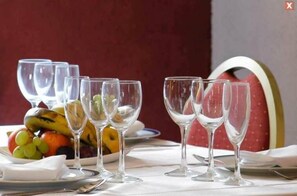 A table set with wine glasses and a fruit platter.