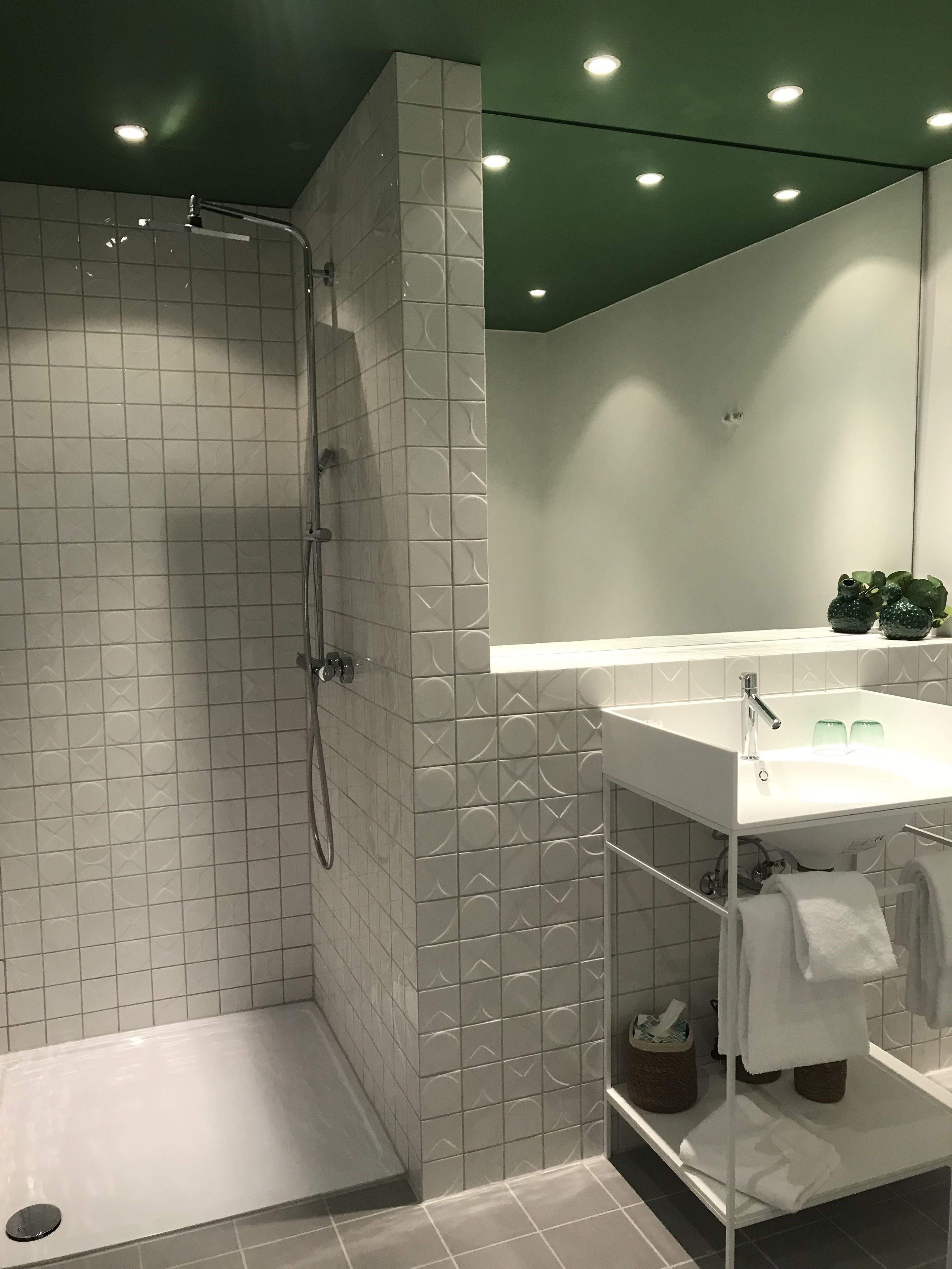 A modern bathroom with a shower, a sink, and a mirror.