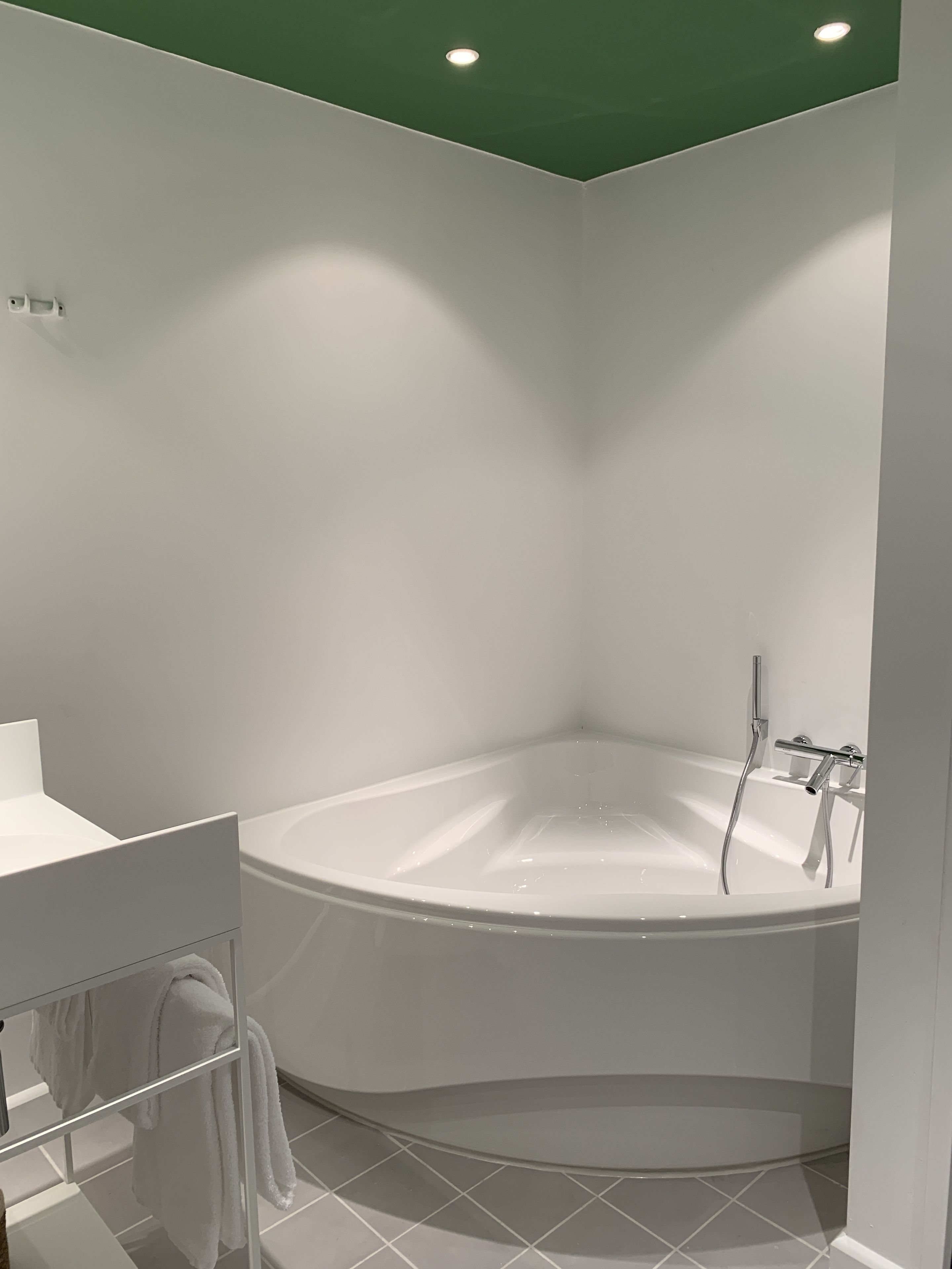 A modern bathroom with a freestanding bathtub, a white sink, and a towel rack.
