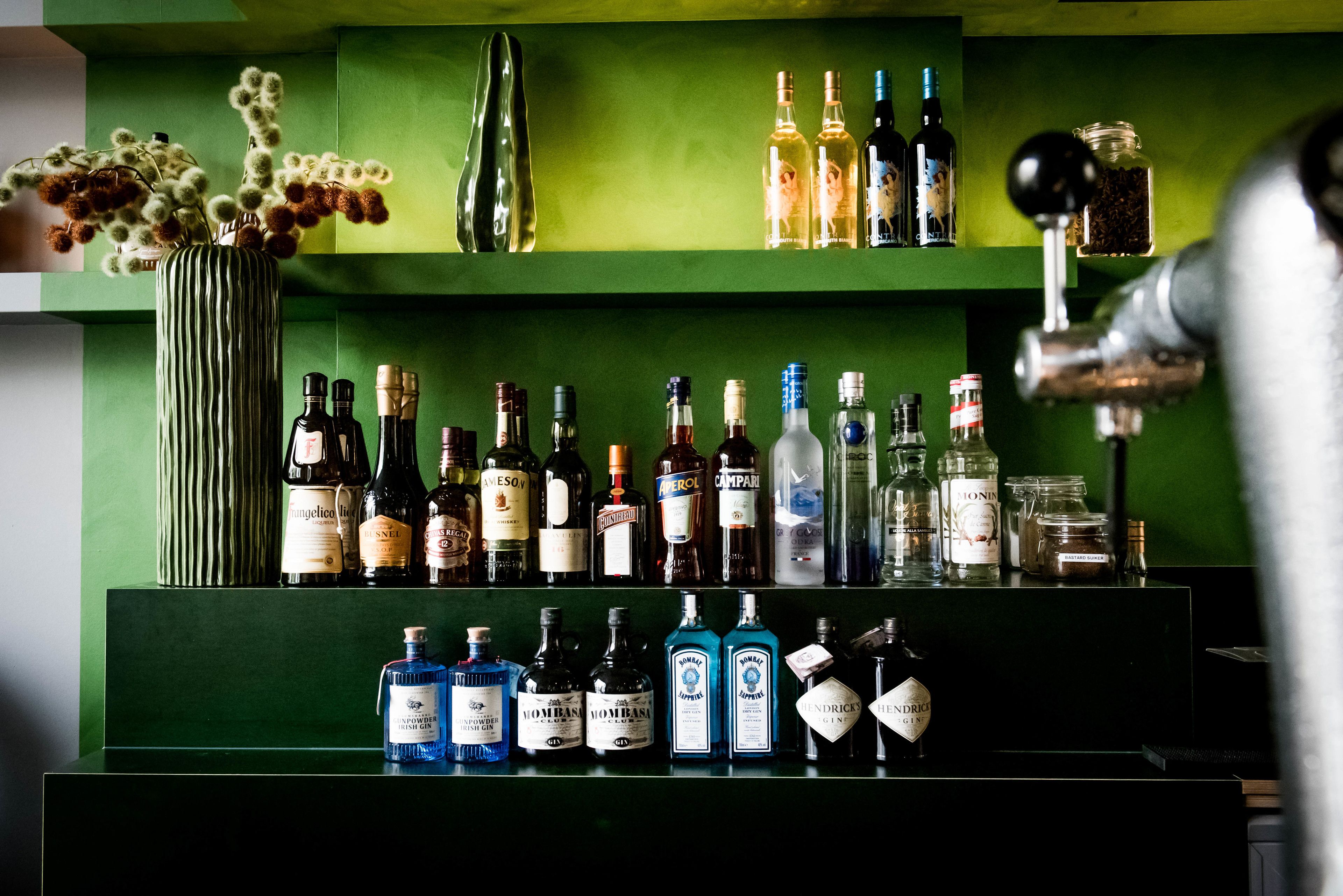 A bar area with various liquor bottles and a coffee machine.