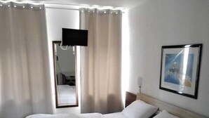 A neatly made bed with white linens, a wooden headboard, and a framed picture on the wall. - Hotel Berliner Hof (Düsseldorf)