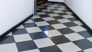 A hallway with a black and white checkered floor, a mirror on the left, and a door at the end. - Hotel Berliner Hof (Düsseldorf)