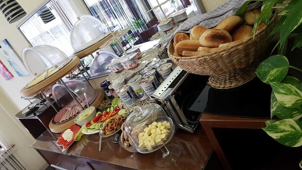 A buffet setup with various food items, including bread, fruits, and deli options. - Hotel Berliner Hof (Düsseldorf)
