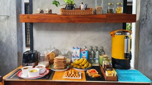 Ein reichhaltiges Frühstücksbuffet mit verschiedenen Speisen, Beilagen und einer Kaffeemaschine.