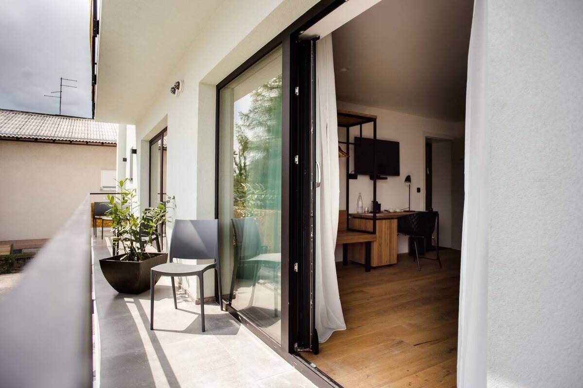 A modern apartment with a balcony, a dining area, and a living space.