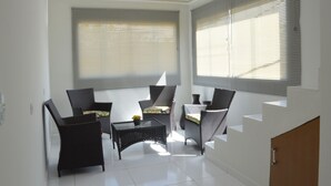 A sunlit room with a sofa, two armchairs, and a small table. - Pousada Ubarana (Maragogi)