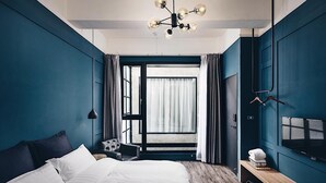 A modern bedroom with a large bed, a ceiling light fixture, a TV, and a window with curtains. - The Gatsby Apartment (Tainan)
