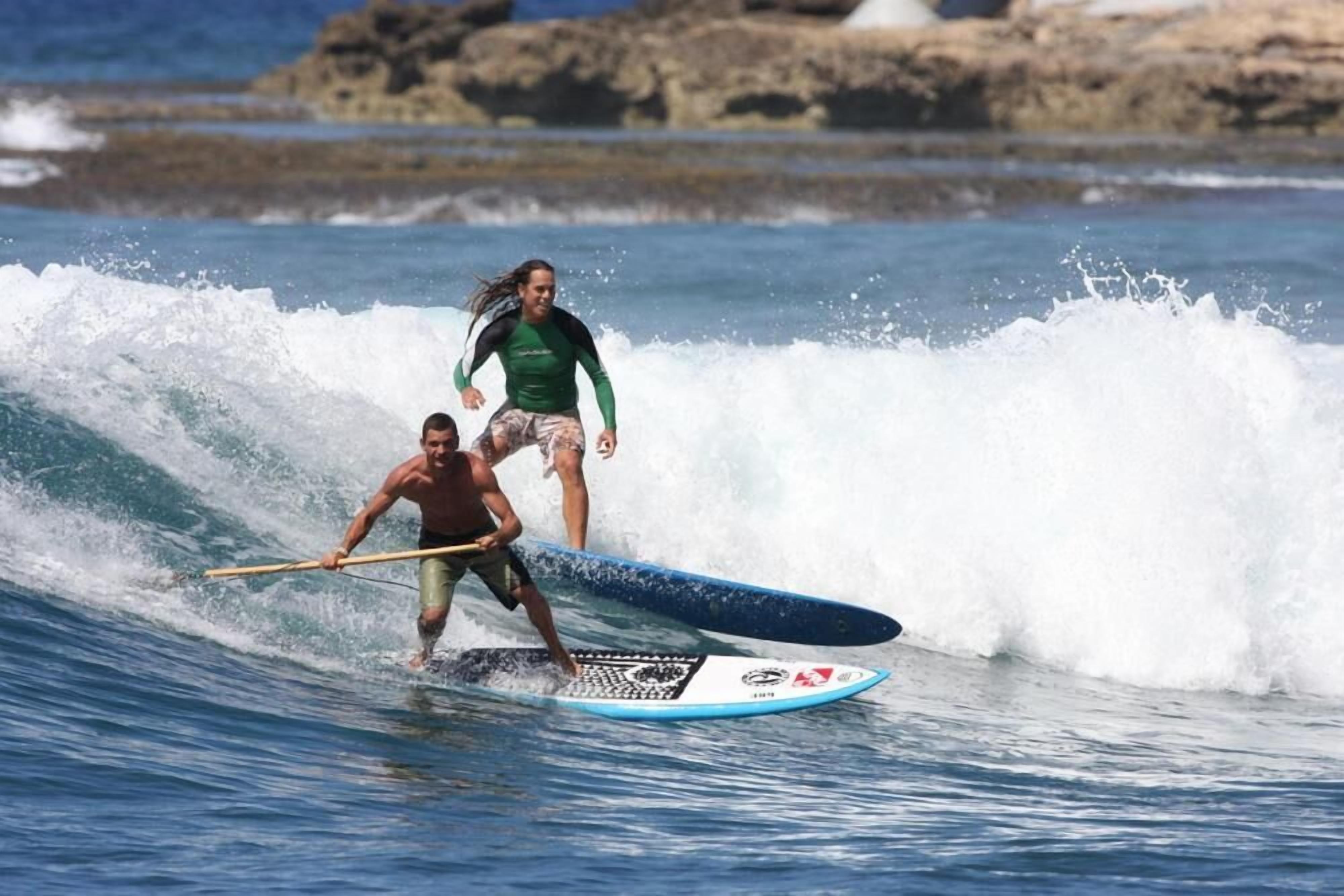 A person surfing on a wave with a surfboard.