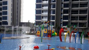 Ein Wasserspielbereich mit Wippe, Wasserstrahlen und bunten Spielgeräten.