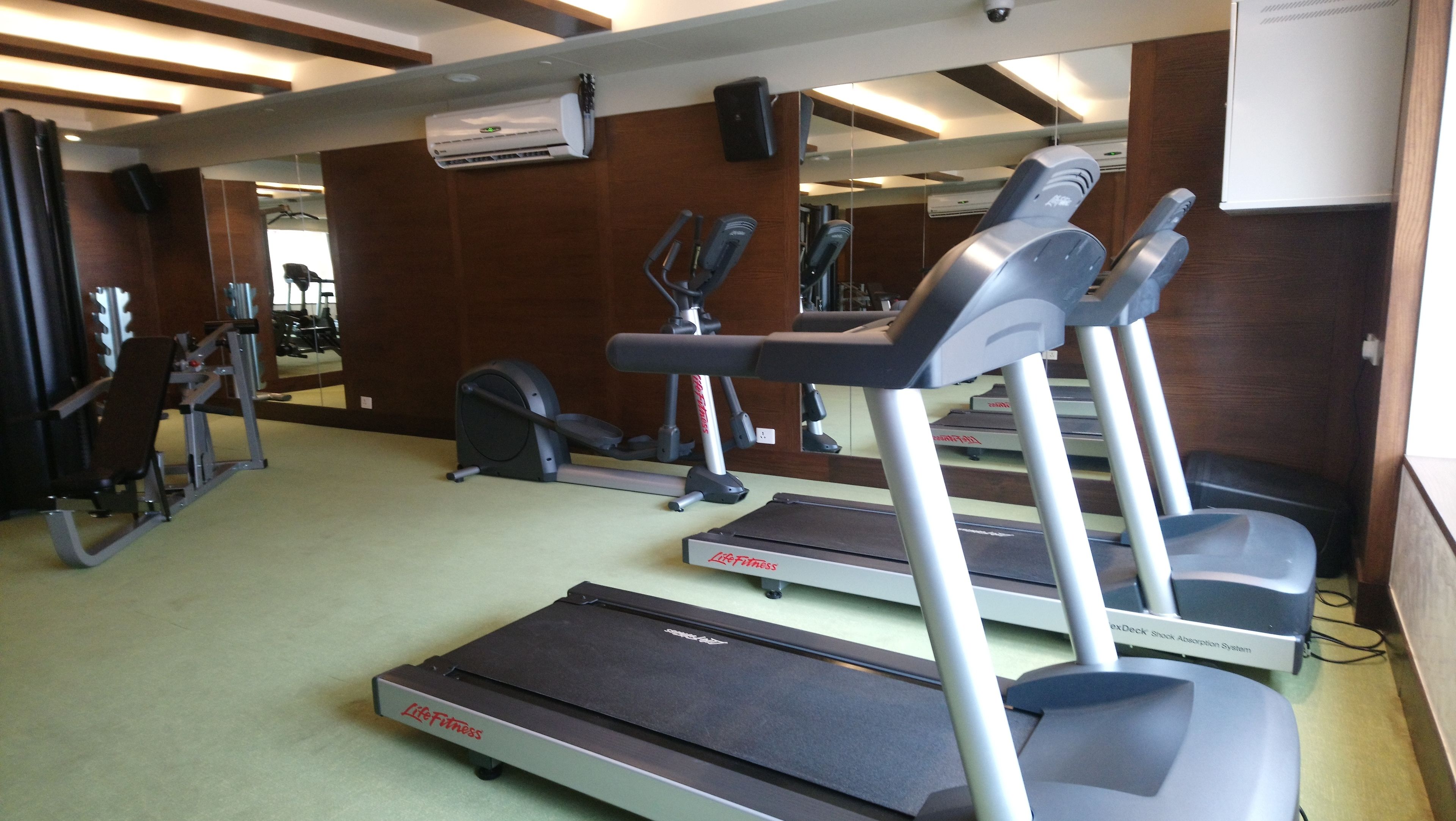 A gym with treadmills, elliptical machines, and weight equipment.