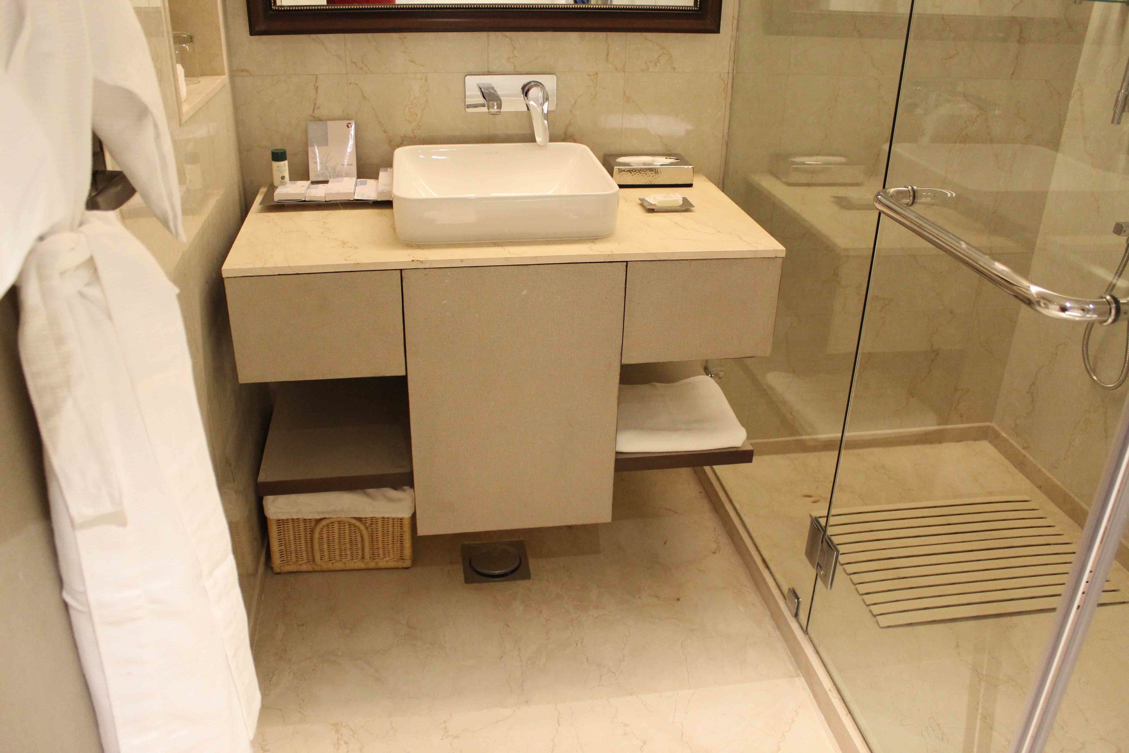 A bathroom with a sink, mirror, and glass shower enclosure.