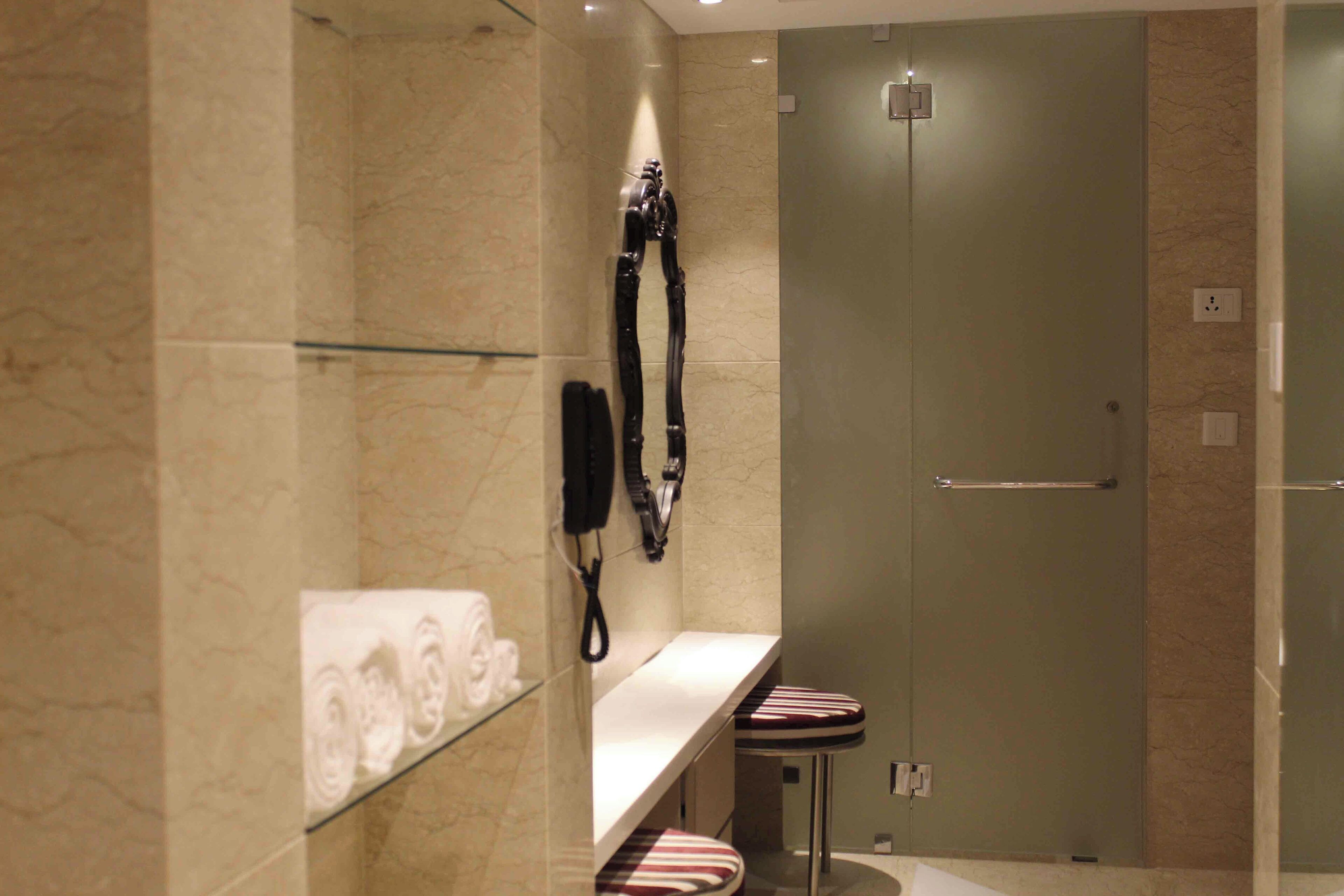 Un baño moderno con cabina de ducha de vidrio, toallero y tocador con espejo.