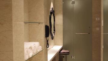Un baño moderno con cabina de ducha de vidrio, toallero y tocador con espejo.