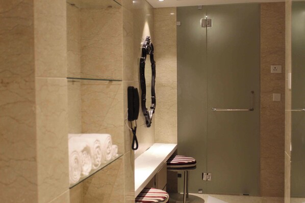 Un baño moderno con cabina de ducha de vidrio, toallero y tocador con espejo.