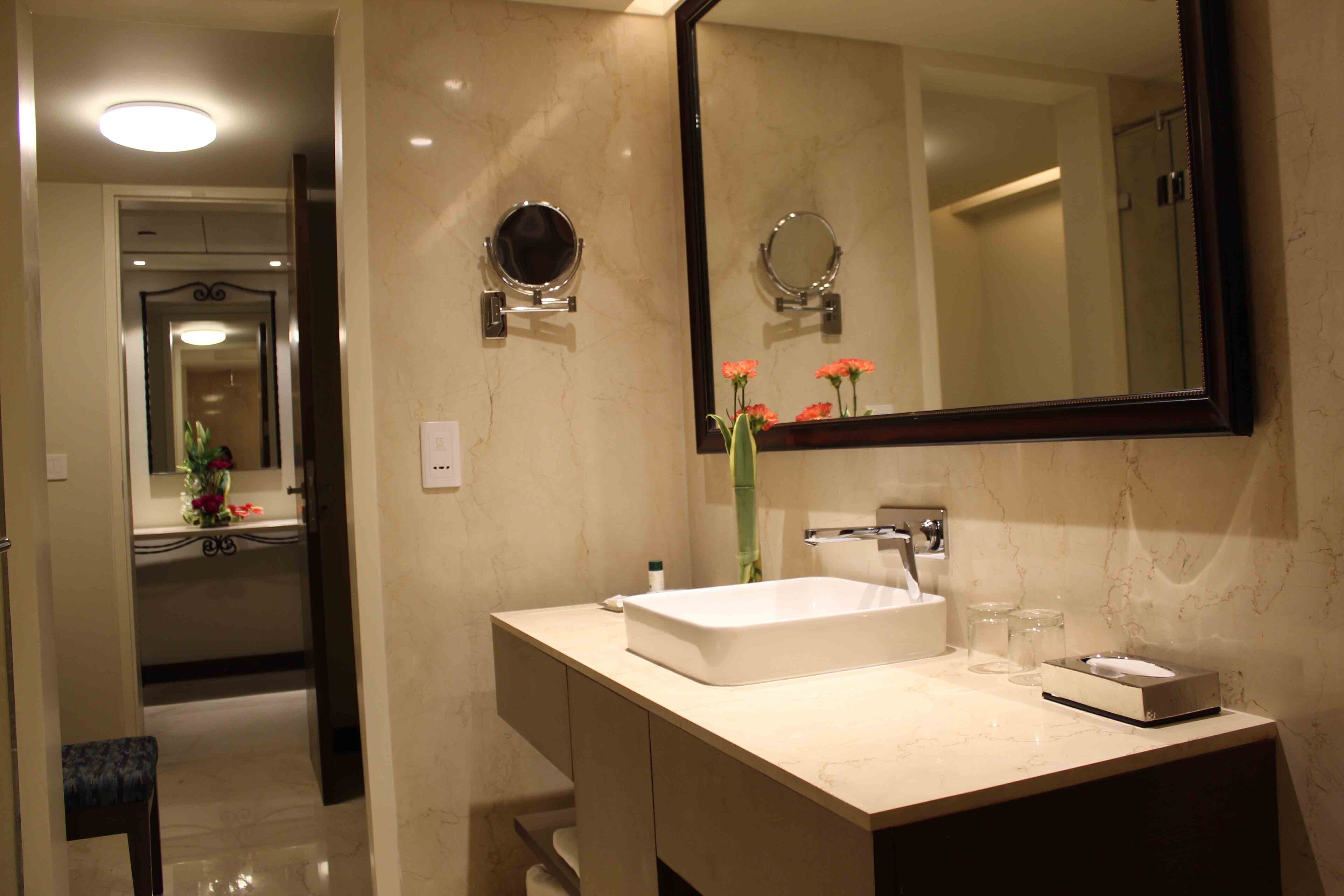 Un baño con un espejo grande, un lavabo y tocador.